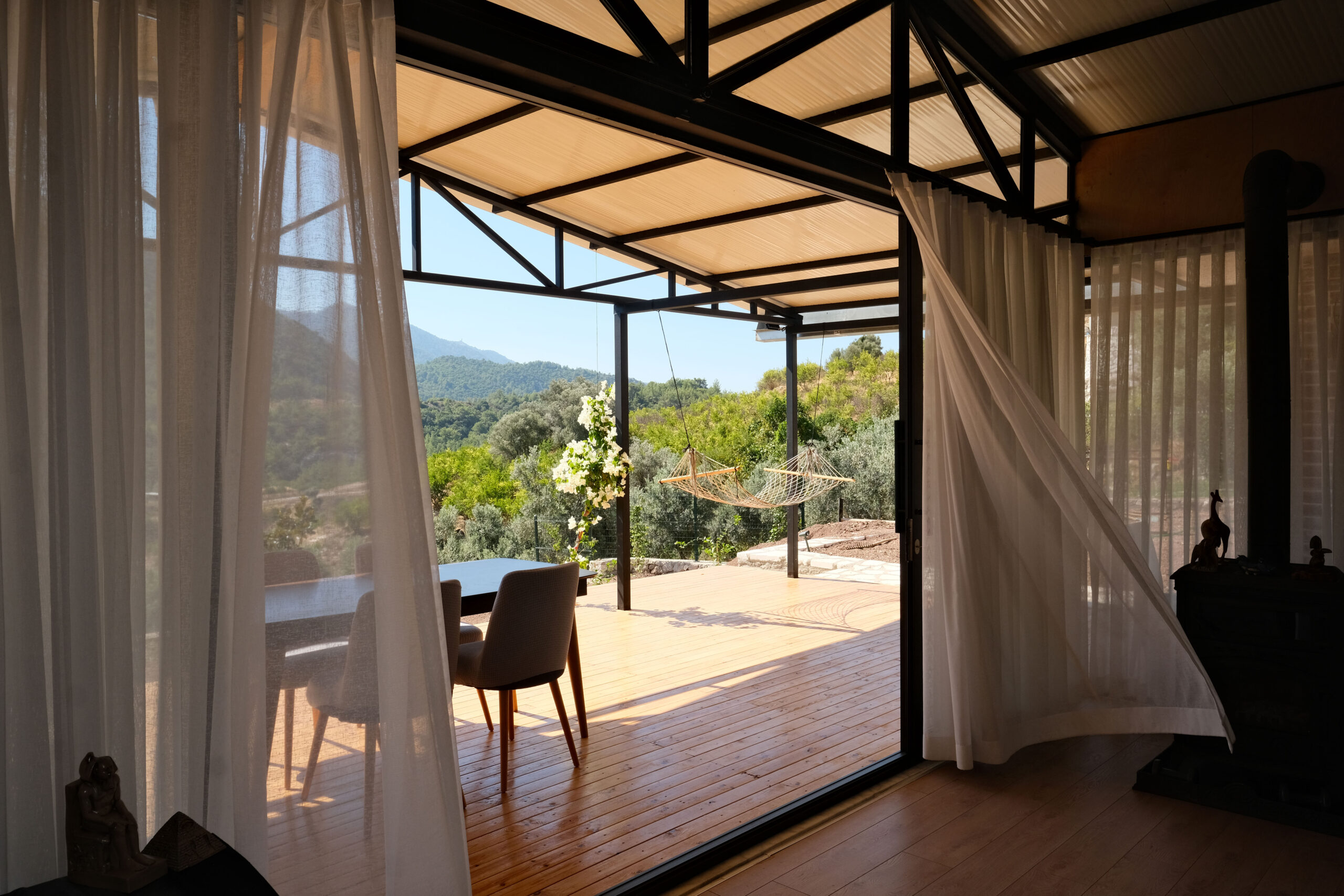 bahçeye açılan geniş teras kapısı ve uçuşan perde