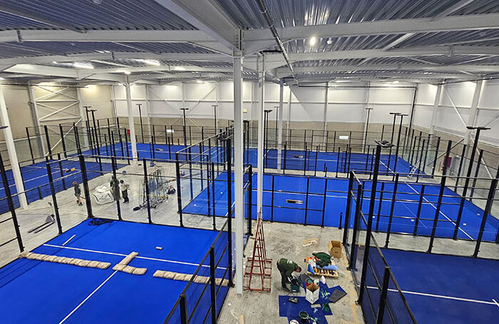 Mavi zeminli kapalı profesyonel padel kortu inşaatı ve cam paneller