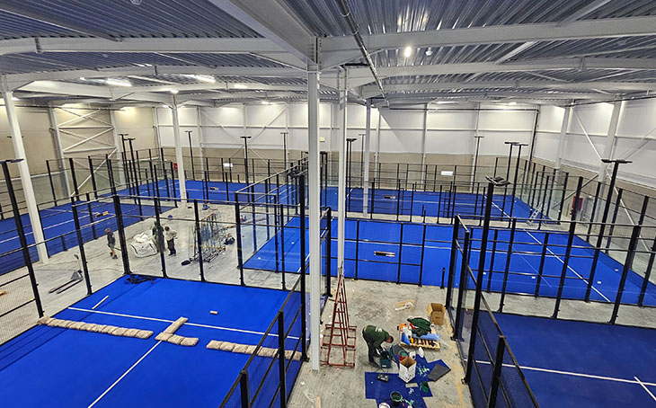 Mavi zeminli kapalı profesyonel padel kortu inşaatı ve cam paneller